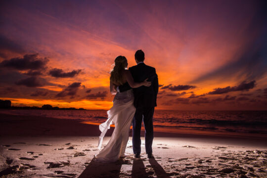 bride and groom on the beach at sunset