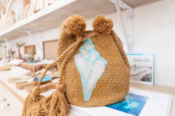 Woven purse with conch shell design in a gift shop