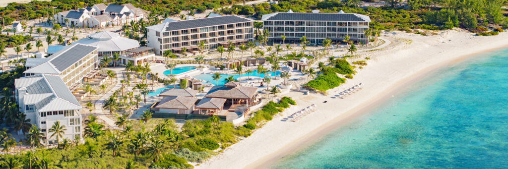 Aerial view of a white-sand beach and luxury resort in Turks and Caicos.