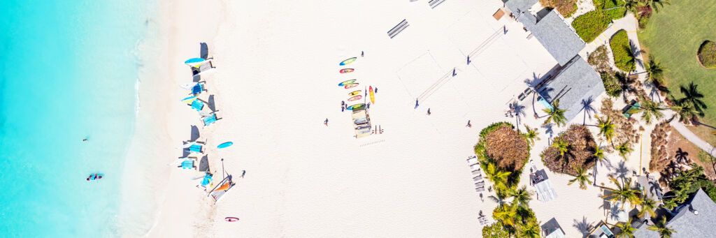Overhead view of Grace Bay Beach with Hobie Cat sailboats, paddleboards, and kayaks.