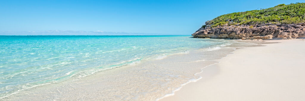 The ocean and beach with a small cliff at Pumpkin Bluff on North Caicos.