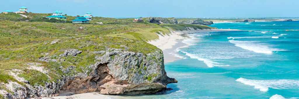Cliffs by the sea at Mudjin Harbour, Middle Caicos, with small resort villas perched on top.