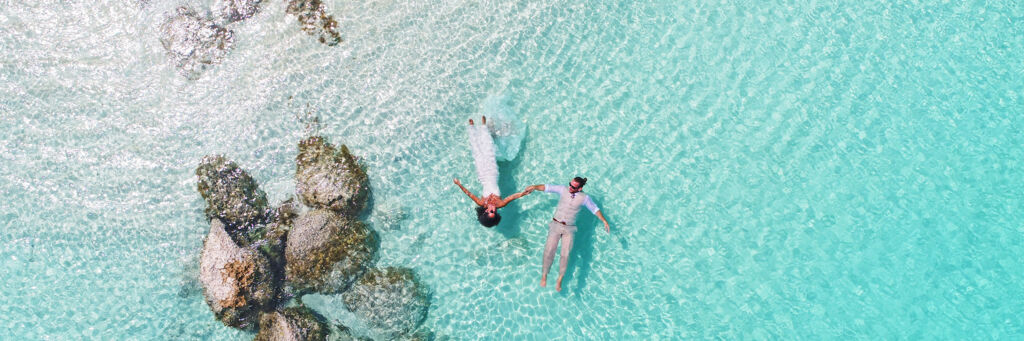 Bride and groom floating on Grace Bay