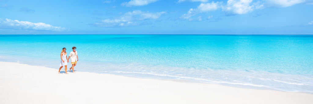 A couple walking on the beach at Water Cay in Turks and Caicos