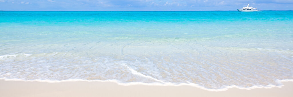White-sand beach with turquoise water on a calm day. 