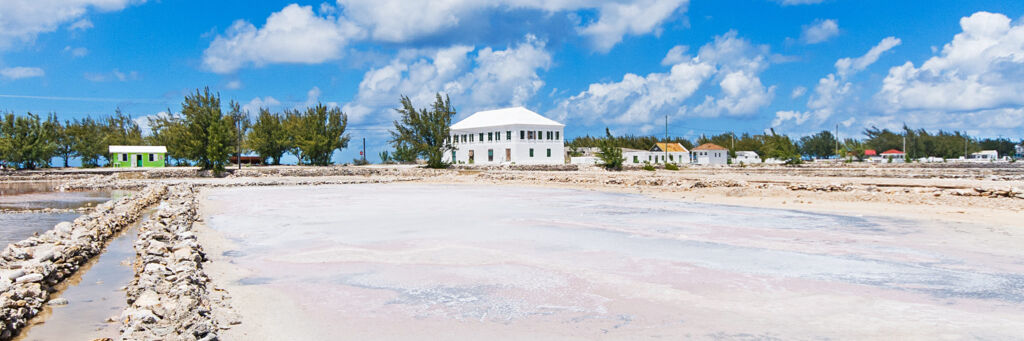 Salt ponds and walls with the white Harriot House in the distance on Salt Cay.