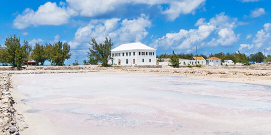 Salt ponds and walls with the white Harriot House in the distance on Salt Cay.