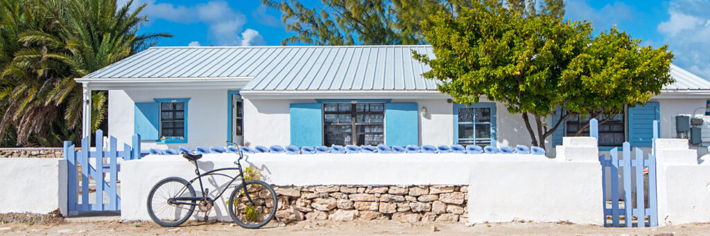 Quaint white and blue house with a bicycle in front on Salt Cay.