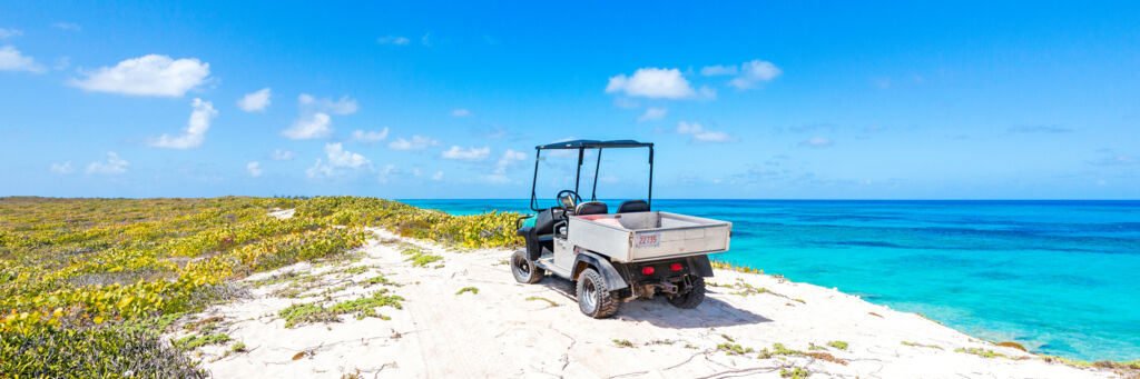 An offroad golf-cart parked on a bluff overlooking the ocean on Salt Cay.