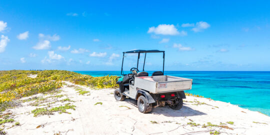 An offroad golf-cart parked on a bluff overlooking the ocean on Salt Cay.