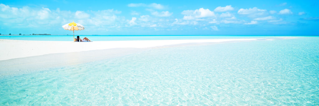 Umbrella and woman on a sandbar in the Turks and Caicos.