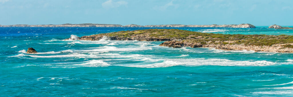 Breaking waves at Shark Bay with Long Cay on the horizon