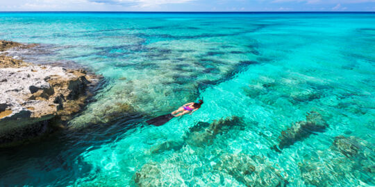 Snorkeler in clear turquoise water in the Turks and Caicos