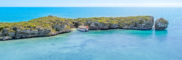 Tour boat exploring ocean cliffs in Turks and Caicos