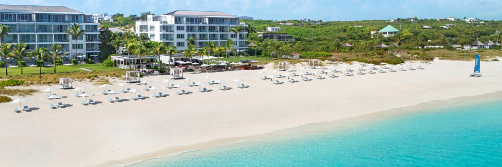 Luxury resort on a white-sand beach with turquoise water.