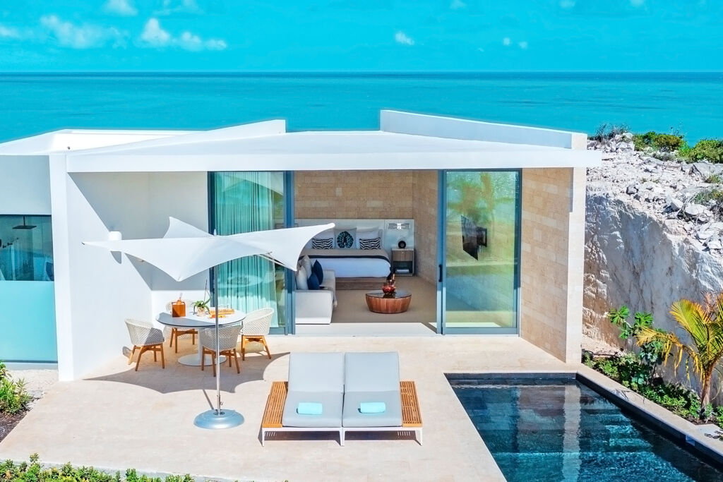 Modern villa and pool on a limestone bluff overlooking turquoise ocean