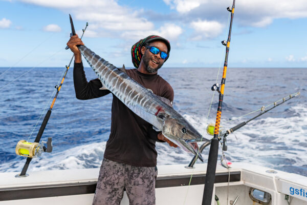 Fisherman with wahoo on a boat.