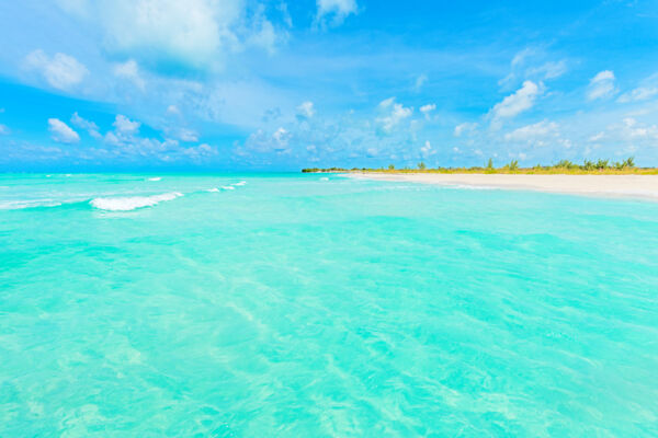 Breaking wave at the turquoise waters of the secluded Fort George Cay