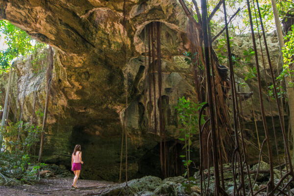 Person standing in the main gallery at Indian Cave on Middle Caicos