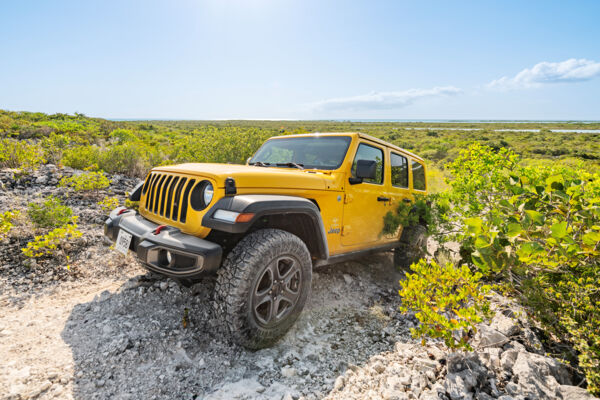 Yellow Jeep climbing a rocky incline in Turks and Caicos.