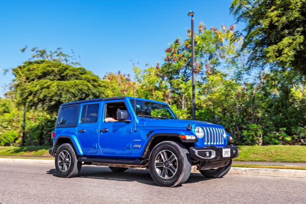 A blue Jeep Wrangler in Grace Bay on Providenciales.