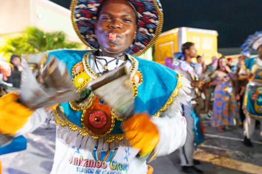 Junkanoo player shaking cowbells at the island fish fry on Providenciales. 