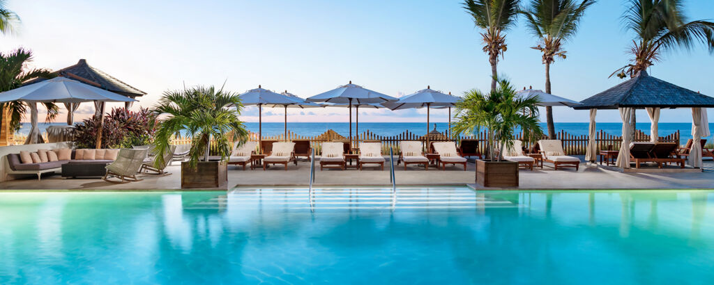 Dusk at a luxury resort's pool overlooking Grace Bay Beach, Turks and Caicos. 