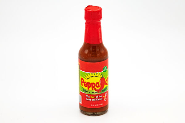 Bottle of Turks and Caicos hot sauce on a clean white background. 
