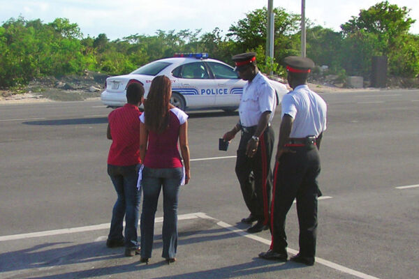 Turks en Caicos politieagenten op de plaats van een auto-ongeluk op de benedenwaartse snelweg op Providenciales