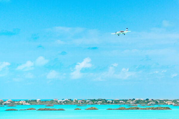 Small twin turbo prop plane approaching the Providenciales International Airport over Chalk Sound