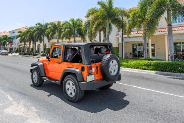 Orange rental Jeep Wrangler driving on Grace Bay Road on Providenciales