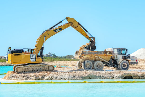 Excavator and articulated dump truck at the South Bank construction site on Providenciales.
