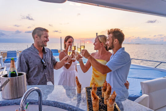 Friends enjoying champagne aboard a super yacht in Turks and Caicos.