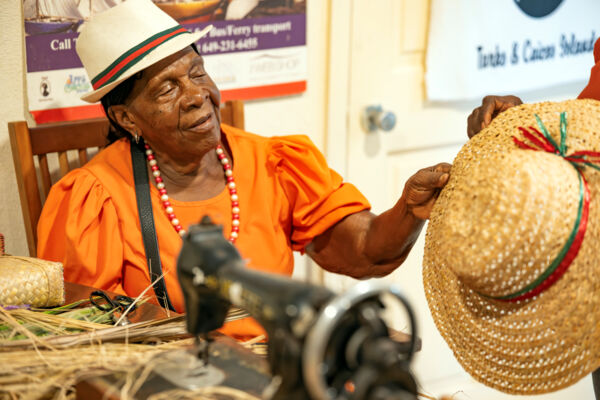 Woman holding a handmade straw hat in Turks and Caicos. 