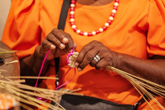 Woman stitching a fanner grass basket at the Middle Caicos Co-op in Turks and Caicos. 