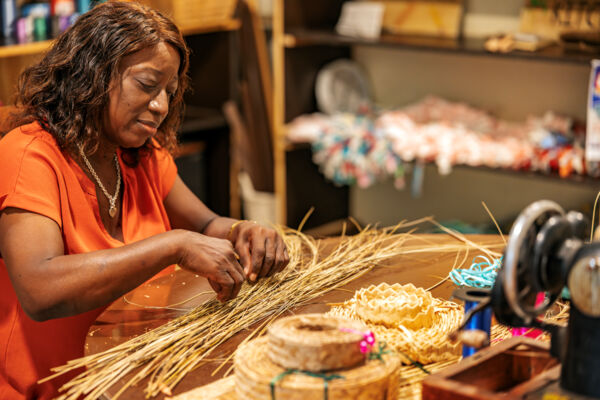 Woman bundling fanner grass for straw work at the Middle Caicos Co-op on North Caicos. 