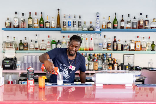 Bartender mixing drinks behind the bar. 