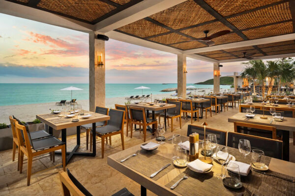 A beachside restaurant and bar at sunset.