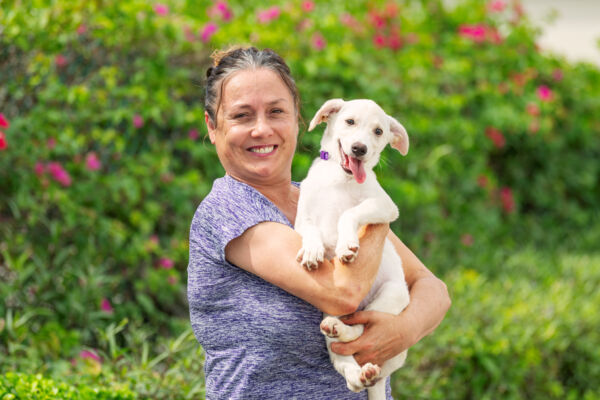 Jane Parker-Rauw of Potcake Place and a young potcake in Turks and Caicos. 