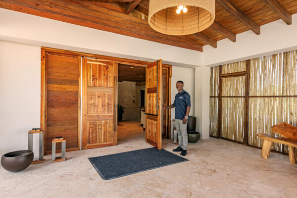 Man holding open the doors to the luxurious Salterra Resort in Turks and Caicos. 