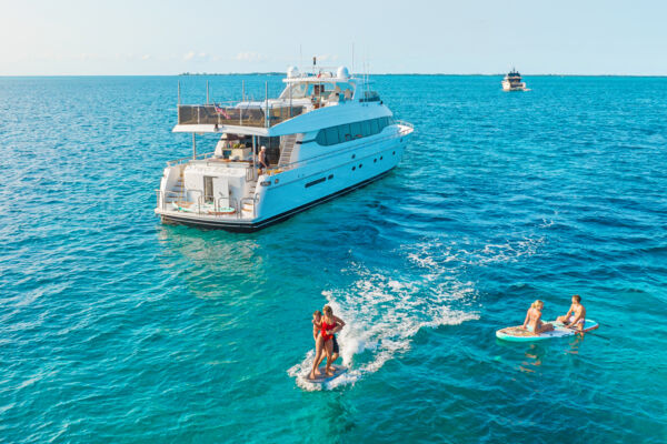 Guests trying e-foiling and paddleboarding on a super yacht in Turks and Caicos.