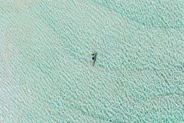 Aerial image of a person floating in shallow water off South Caicos. 