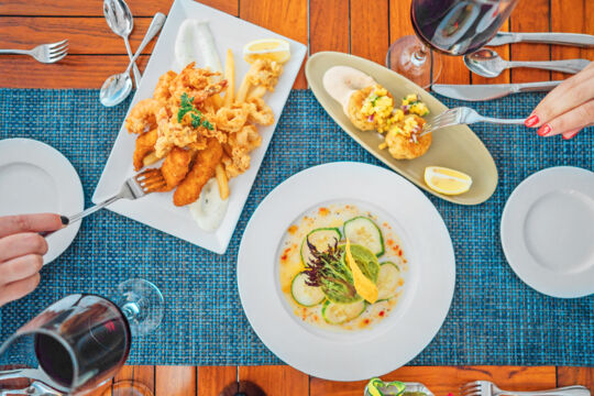 Overhead of several plates of seafood at a restaurant