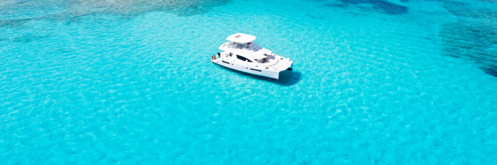 Aerial view of clear water and reef with yacht