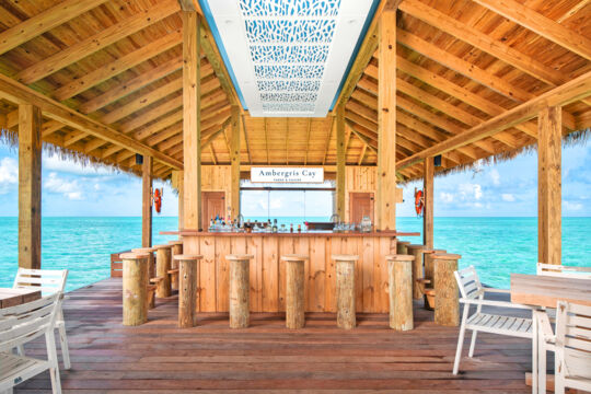 Bar stools at a wooden floating tiki bar in Turks and Caicos