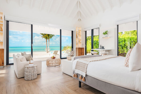Luxury suite with floor-to-ceiling windows on a white-sand beach