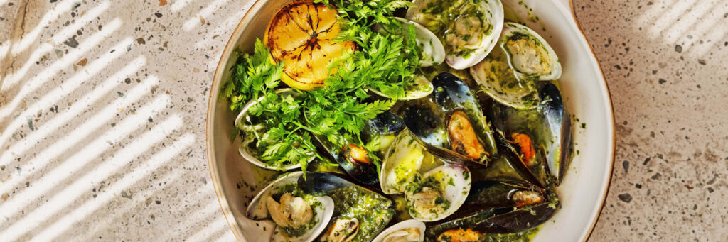 Plate of mussels and clams on table. 