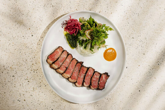 Sliced ribeye steak on plate. 
