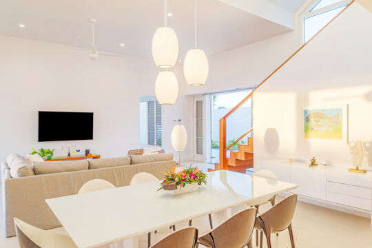 Modern interior with dining table, couch, and TV.