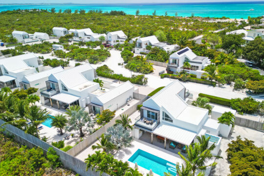 Aerial view of a villa enclave located near forest and a beautiful beach